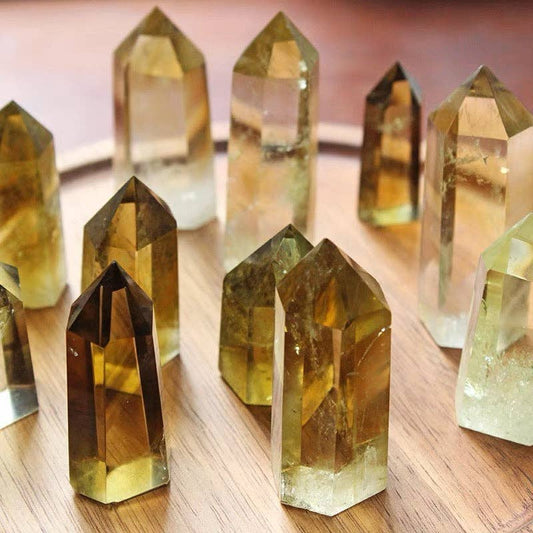 A display of AAAA Grade Natural Brazilian Citrine Tower crystals arranged on a wooden surface